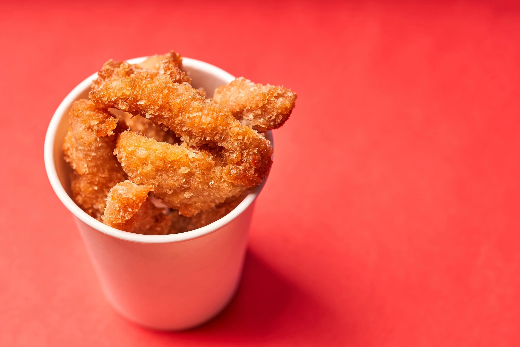 fried chicken tenders on red background
